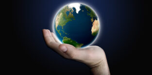 Eine Weltkugel liegt auf einer Handfläche.