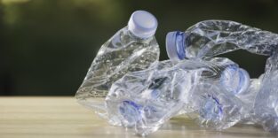 Zerknüllte Plastikflaschen liegen auf einem Tisch. Symbolbild für die neue Möglichkeit, Plastik zu recyceln.