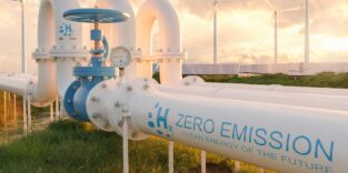 Blick auf Pipelines mit Windrädern im Hintergrund. Schriftzug auf der Pipeline, der erläutert, dass es sich um ein Wasserstoffnetz handelt.