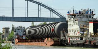 Heavy oversized chemical apparatus is transported by river transport through the shipping channel on a special barge