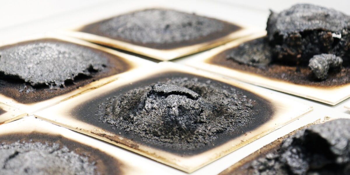 Verschiedene intumeszierende Beschichtungen nach der Beflammung im Laborbrandprüfstand des Fraunhofer WKI. Die Tests geben Aufschluss darüber, mit welcher Rezeptur sich das darunterliegende Holz am besten schützen lässt. Foto: Fraunhofer WKI/Manuela Lingnau