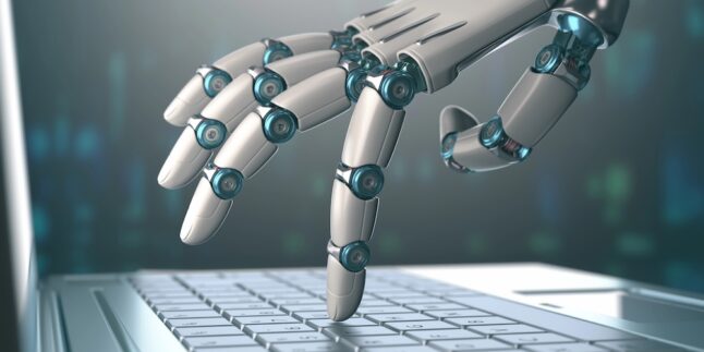 Roboterhand tippt mit einem Finger auf einer Notebook-Tastatur.