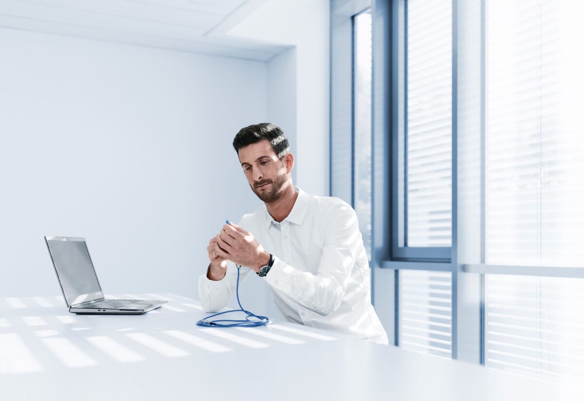 Philipp schraubt eine flexible Hülse aus Silikon auf ein Handstück. Sie soll die Hornhaut vor Schäden durch die mechanisch schwingende Nadel schützen und Flüssigkeit zielgerichtet ins Auge leiten, um ein Kollabieren des Auges durch die Absaugung der Linse zu verhindern. Foto: Zeiss