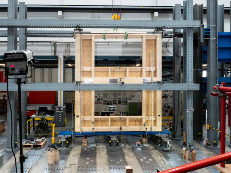 Eine zweigeschossige Hauswand mit Fensteröffnungen wird kontrolliert unter Druck gesetzt