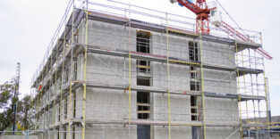 Ein Portaldrucker trägt Schicht für Schicht Beton auf – in Heidelberg entsteht Deutschlands erstes seriell gedrucktes Mehrfamilienhaus.