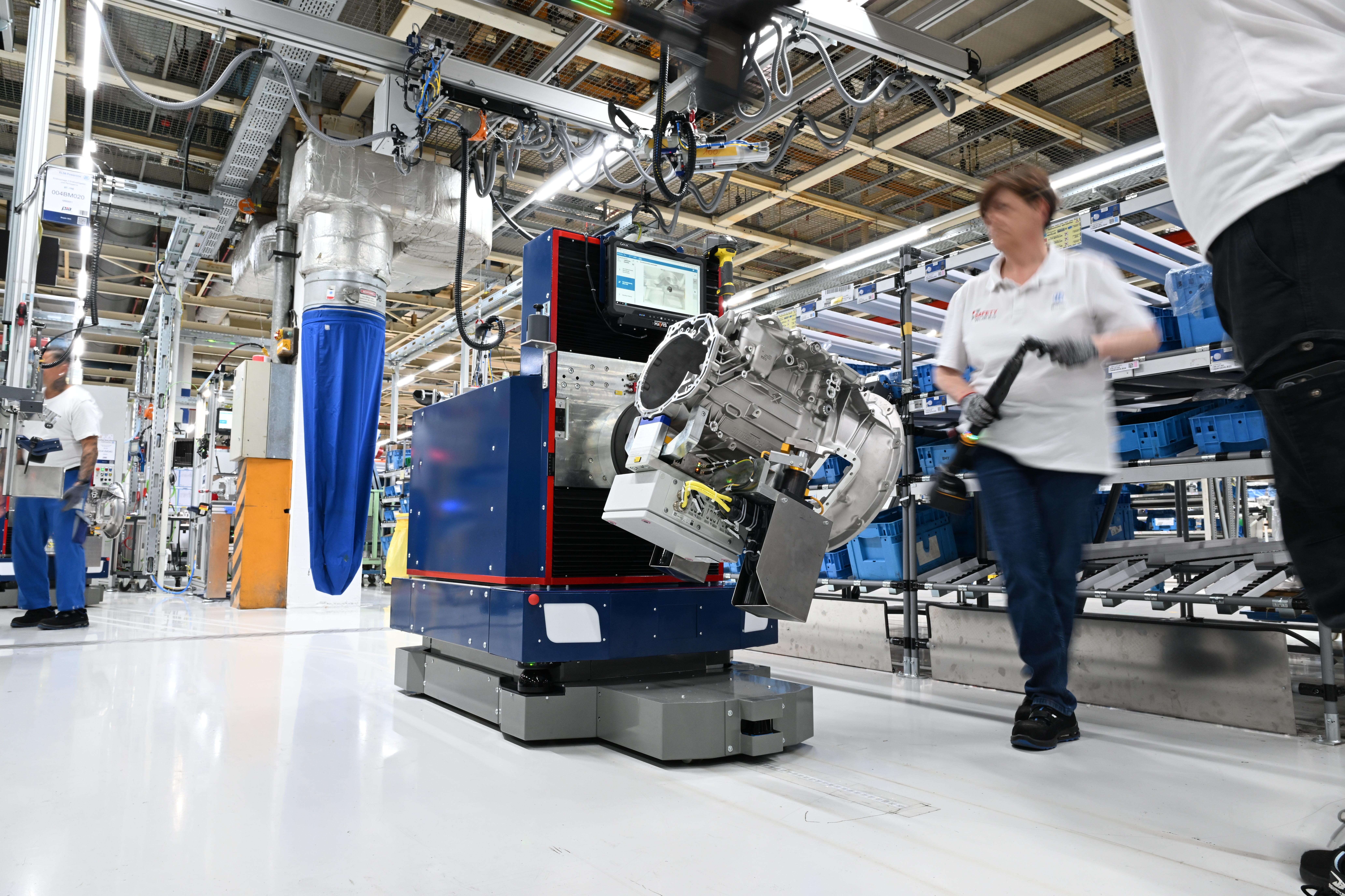 Eine Mitarbeiterin von der ZF Friedrichshafen AG arbeitet an der Montagelinie des Nutzfahrzeuggetriebes PowerLine. Bewegt wird das Getriebe von einem autonomen fahrerlosen Transportfahrzeug (AGV).Foto: picture alliance/dpa/Felix Kästle