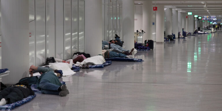 Menschen ruhen sich nach möglichen Drohnensichtungen am Flughafen München aus