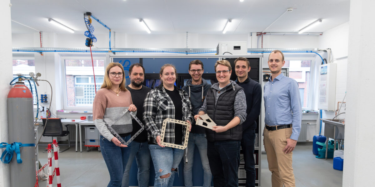 Das Projektteam vor einem Teststand für Brennstoffzellenstacks (v.l.n.r.): Hannah Zeibig (H2Raum), Jeffrey Roth (Westfälische Hochschule), Annika Neuwinger (Westfälische Hochschule), Daniel Burow (ProPuls), Ulrich Rost (ProPuls), Philipp Neuhaus (ProPuls) und Tim Peil (H2Raum). Foto: H2Raum