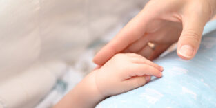 Frau greift Babyhand