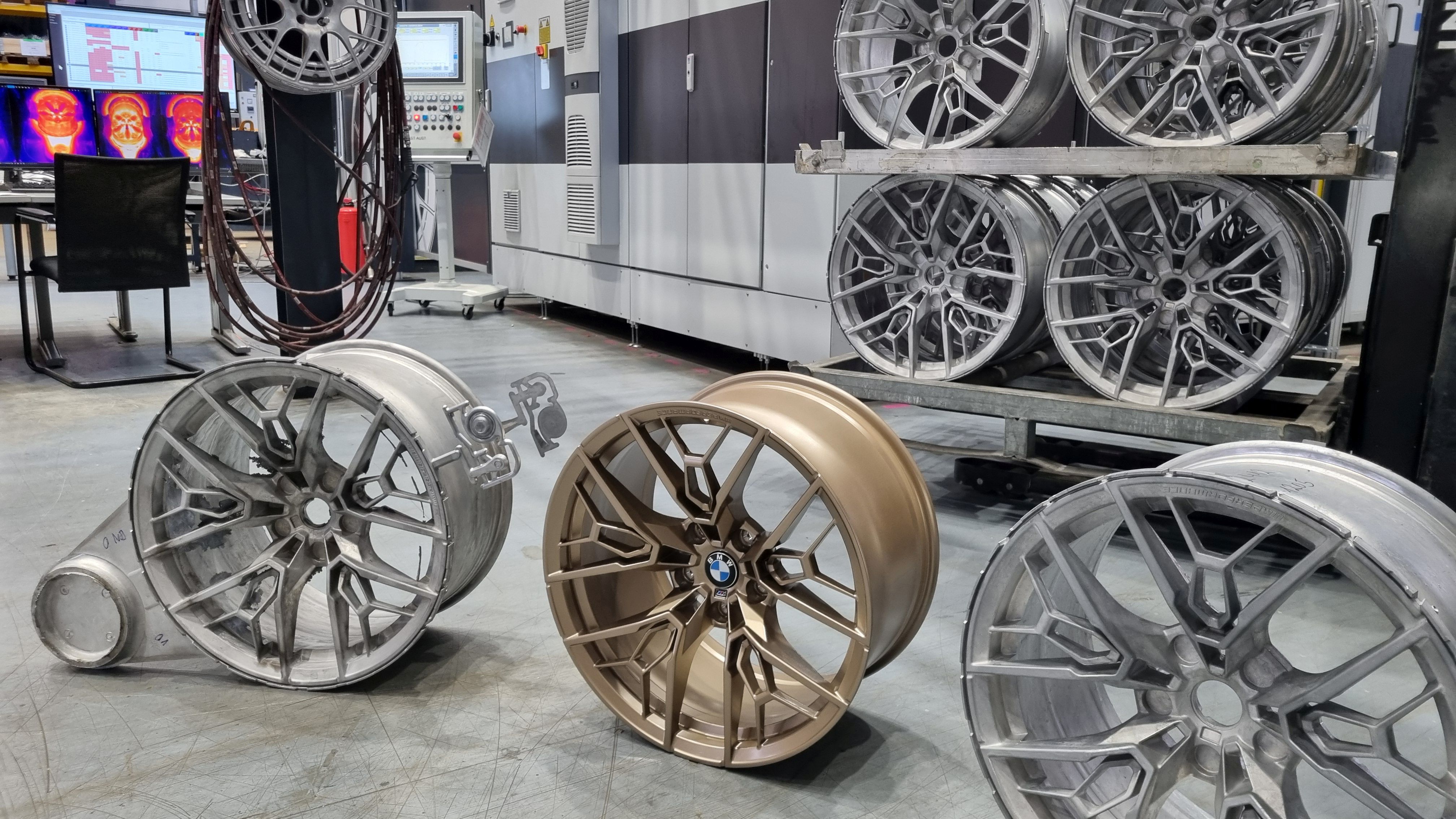 Filigran und ressourcenschonend: Pkw-Aluräder von Entec-Stracon sind leichter und stabiler als herkömmliche, individuell im Design und bestehen zu 100% aus Recycling-Material. Durch die prozessbegleitende Qualitätskontrolle mittels hunderter Sensoren entsteht kein Ausschuss. Im Bild: Rohlinge und ein fertiges Rad. Foto: Entec-Stracon GmbH