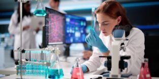 Frau in weißem Kittel arbeitet in einem Labor