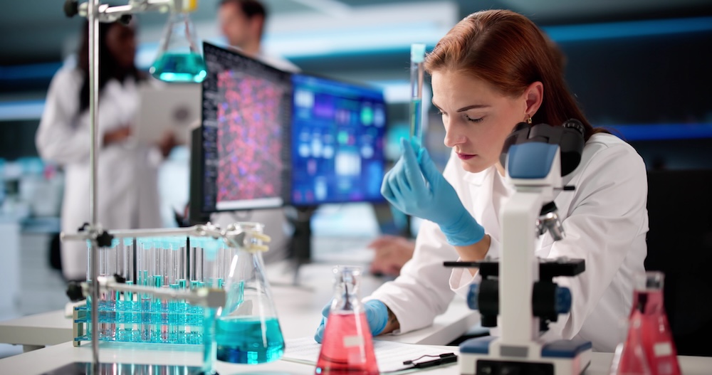 Frau in weißem Kittel arbeitet in einem Labor