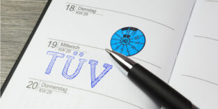 Ein aufgeschlagener Kalender mit dem Vermerk "TÜV" und einer TÜV-Plakette