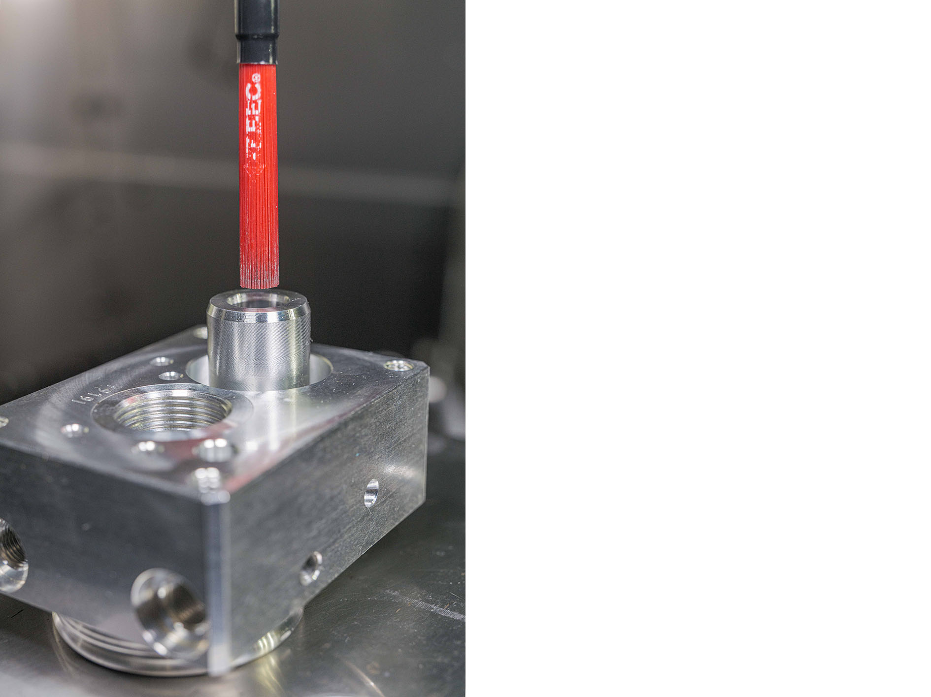 Rechter Ausbruch am Bohrungsgrund: die Tieflochbohrung endet halboffen in der Bodenfläche und im Freistich entsteht ein Grat, der nur durch die Keramikfaser-Bürste vom Typ "BÜCHA127M" entgratet werden kann. Unter Drehzahl spreizen sich bei diesem Bürsten-Typ die einzelnen Fasern durch die Fliehkraft auf. Foto: Kempf