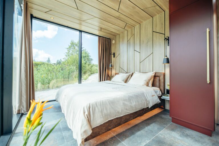 Das Schlafzimmer des Golden House: maßgefertigtes Kingsize-Bett, goldakzentuierte Leuchten und Eichenpaneele schaffen auf wenigen Quadratmetern eine klare, technisch durchdachte Raumstruktur.Foto