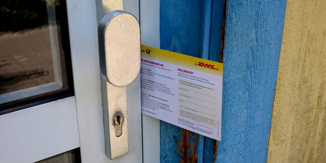 DHL-Abholschein steckt in der Haustür