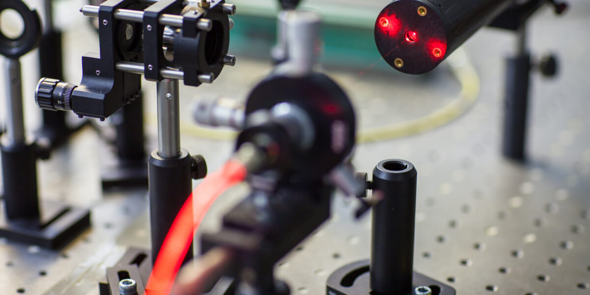 Quantum optics lab installations with laser, irises, appertures - laser reflect on optic table un quantum laboratory