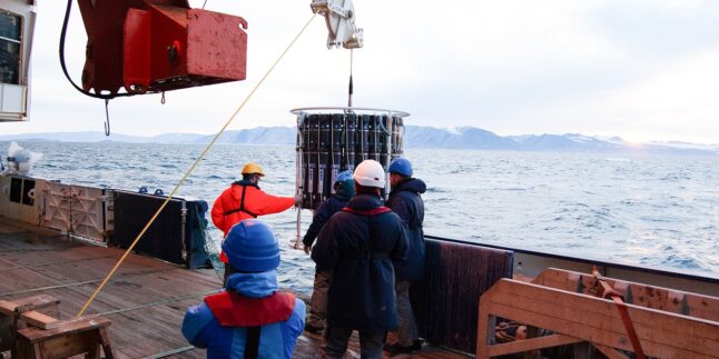 Forschende bei Messungen zum Bleigehalt im Ozean, die Messgeräte von einem Forschungsschiff ins Wasser lassen.