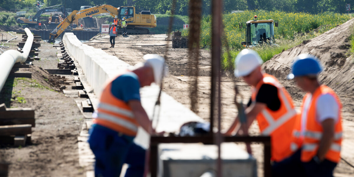 Mitarbeiter der Ontras Gastransport GmbH arbeiten bei der Erneuerung der Ferngasleitung Lauchhammer-Strehla an einem Rohrstrang zur Gewässerquerung, auch Düker genannt, am Ufer der Elbe. Die Erneuerung des rund 35 Kilometer lange Abschnitts soll eine effiziente Energieversorgung für die Regionen zwischen Lauchhammer und Riesa sicherstellen. (Luftaufnahme mit Drohne)