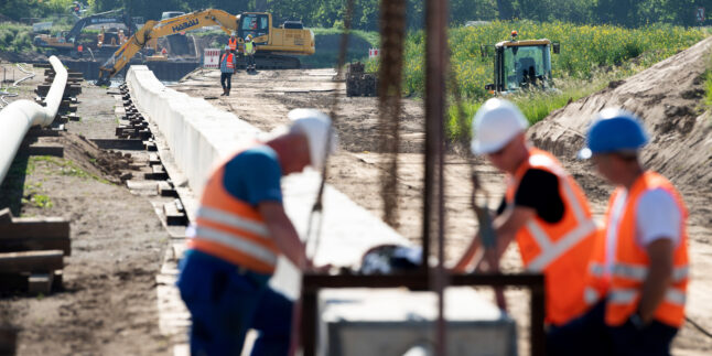 Mitarbeiter der Ontras Gastransport GmbH arbeiten bei der Erneuerung der Ferngasleitung Lauchhammer-Strehla an einem Rohrstrang zur Gewässerquerung, auch Düker genannt, am Ufer der Elbe. Die Erneuerung des rund 35 Kilometer lange Abschnitts soll eine effiziente Energieversorgung für die Regionen zwischen Lauchhammer und Riesa sicherstellen. (Luftaufnahme mit Drohne)
