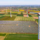 Solar modules of a solar park with wind turbines to produce green electricity for the Energiewende seen from above