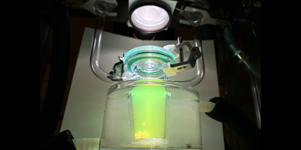 Laborreaktor mit grün leuchtender Flüssigkeit zur Wasserstoffproduktion aus Sonnenlicht an der Chalmers University