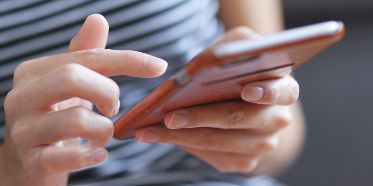 Frau tippt in Smartphone