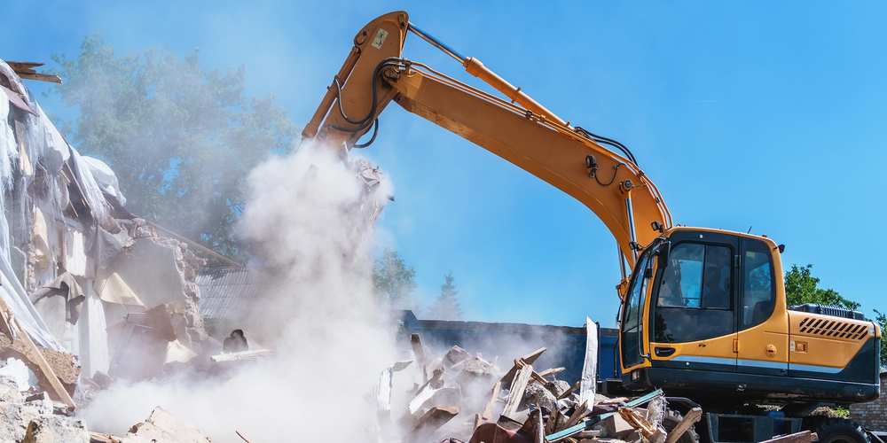 Demolition of building. Excavator destroy old house