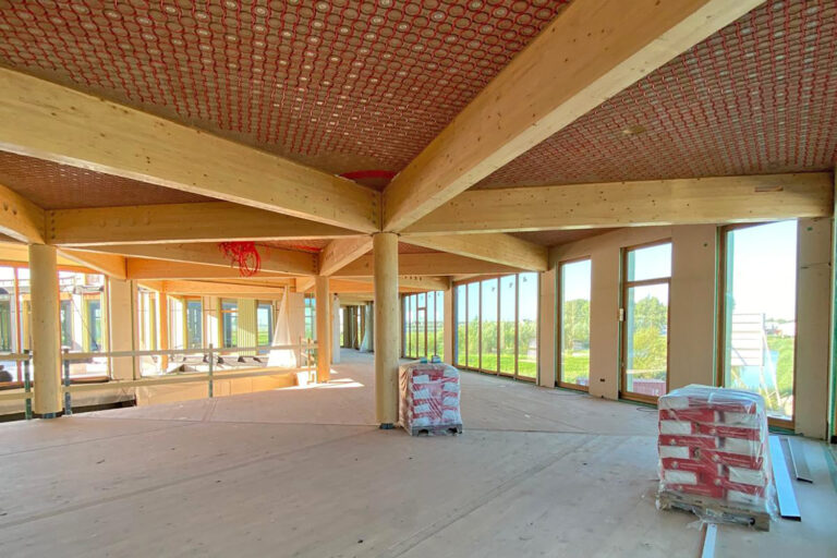 Deckenarchitektur mit Holzbalken und Flächenkühlung