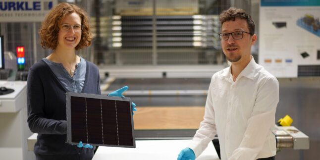 Zwei Rekorde auf einen Streich: Projektleiterin Dr. Laura Stevens zeigt ein III-V-Germanium-PV-Modul mit einer Rekordeffizienz von 34,2 %. Leonhard Böck (r.) ist Projektmitarbeiter und hat am vor ihm liegenden III-V-Silizium-PV-Modul mit 31,3 % Effizienz mitgearbeitet.