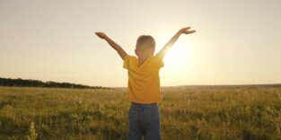 Junge in T-Shirt schaut Richtung Sonne