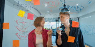 zwei Kollegen unterhalten sich im Büro