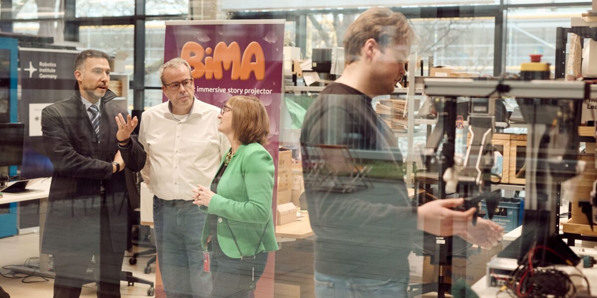 Unterstützen Robotik-Start-ups (v.l.n.r.):  Prof. Lorenzo Masia (Leiter des MIRMI), Nicole Ebner (Managing Director des Inkubators „robo.innovate“) und Prof. Eckehard Steinbach (Vorstand des MIRMI). (Rechts im Bild: Jannik Grothusen, Gründer des Start-ups The Robot Learning Company.) Foto: Steffen Kastner 
