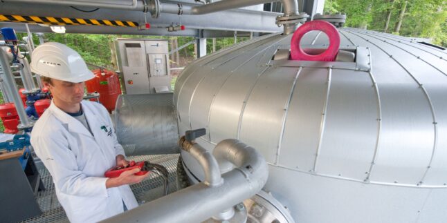 Ein Mitarbeiter steht im Deutschen Zentrum für Luft- und Raumfahrt (DLR) in Stuttgart neben einem Hochtemperatur-Wärmespeicher