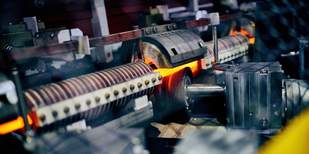 Stahlstab, den Induktionsspulen in Georgsmarienhütte glühend heiß erhitzen