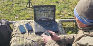 Eine Person steuert eine Drohne und überwacht sie über einen Monitor