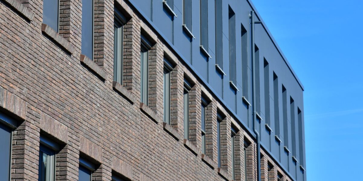 Aufstockung eines Bestandsgebäudes mit Holzrahmenbau, Gipsfaser-Platten und moderner Faserzementfassade für neue Büroflächen.