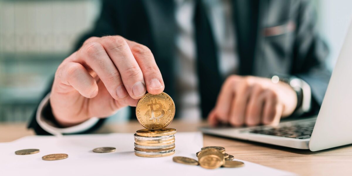 Geschäftsmann spielt mit Bitcoin-Münze