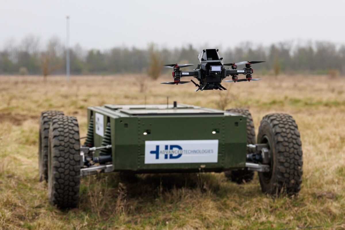 Eine Abwehrdrohne schwebt über einem autonomen Geländefahrzeug