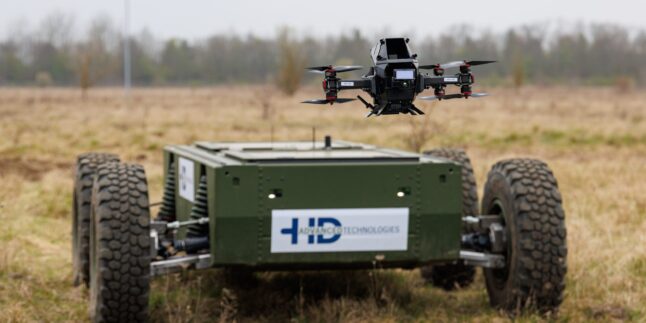 Eine Abwehrdrohne schwebt über einem autonomen Geländefahrzeug