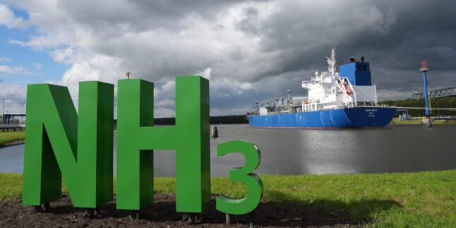 Der mit Ammoniak beladene Flüssiggastanker „Yara Sela“ liegt am Kai des neuen Ammoniak-Importterminals des norwegischen Unternehmens Yara im Hafen Ostermoor. Im Vordergrund steht das Summensymbol „NH3“, die Bezeichnung der chemischen Verbindung von Ammoniak.