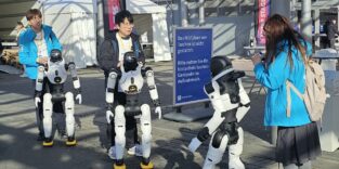 Drei humanoide Roboter auf dem Freigelände der Messe in Hannover