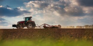 Traktor fährt über Acker