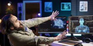 Mann streckt vor PC die Hände aus
