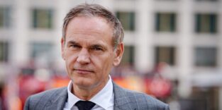 Mann mit Anzug schaut in die Kamera