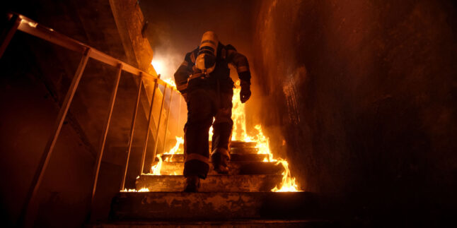 Feuerwehrmann läuft brennende Treppe hoch