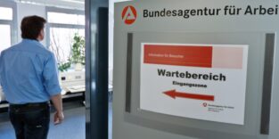 Ein Mann schaut nach Jobangeboten bei der Arbeitsagentur