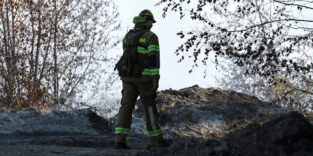Ein Feuerwehrmann durchquert das Waldgebiet nahe Meuselwitz