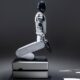 Weißer knieender Roboter vor schwarzem Hintergrund