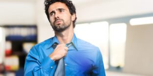 Mann mit Krawatte schwitzt im Büro